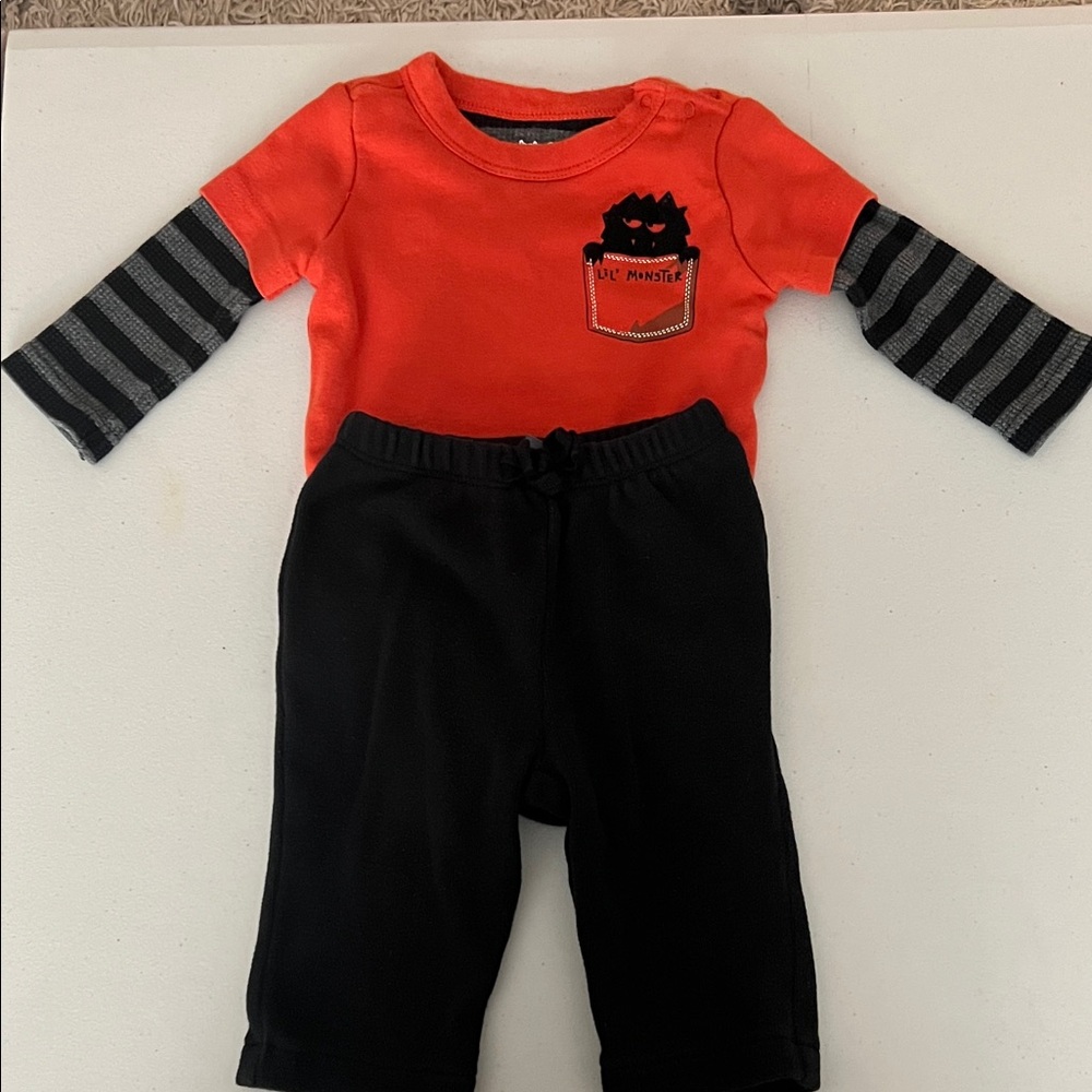GAP Orange Baby Top with Black Monster Design and black pants.